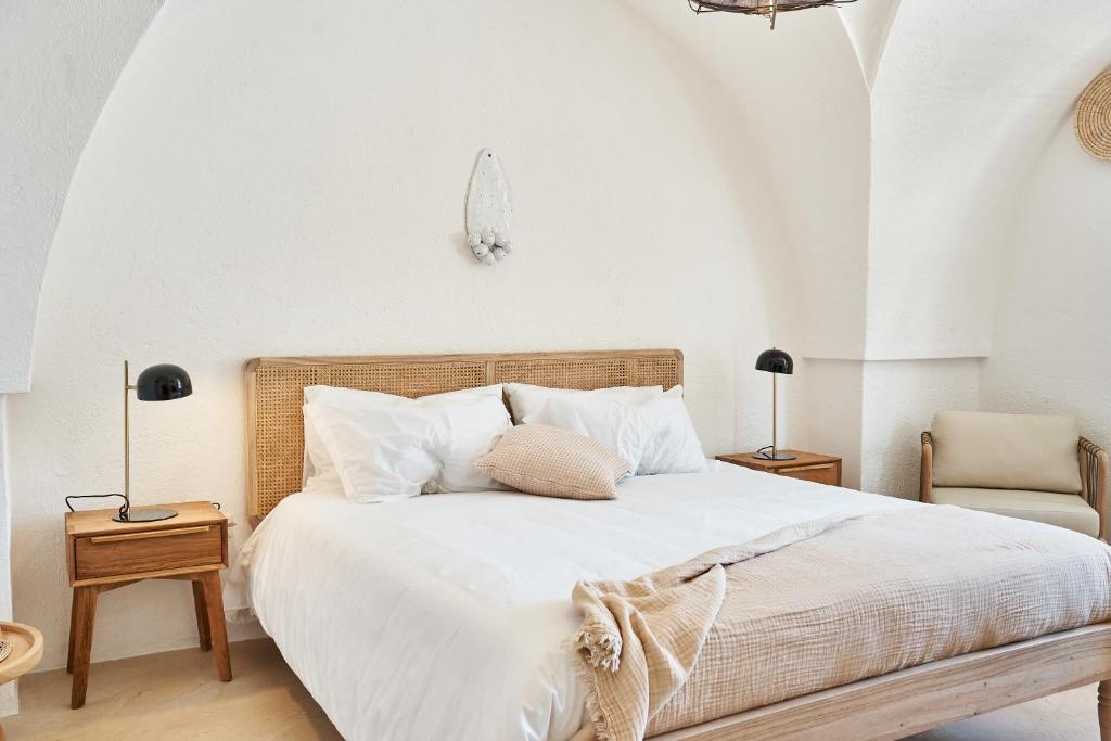 a bedroom with a bed with white sheets and pillows at Il Trappetello in Monopoli