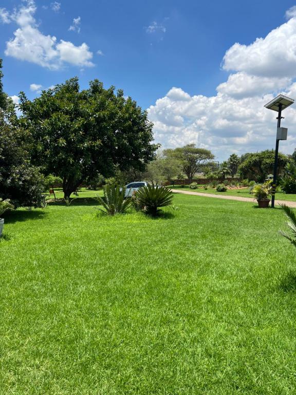 un campo de césped verde con un coche en el fondo en Miami Gardens, en Roodepoort