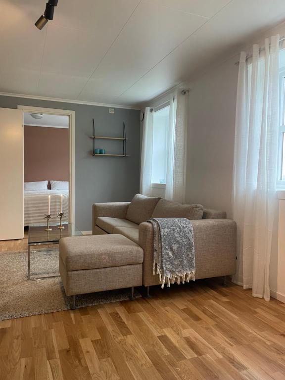 a living room with a couch and a chair at Cozy apartment with a view in Tromsø