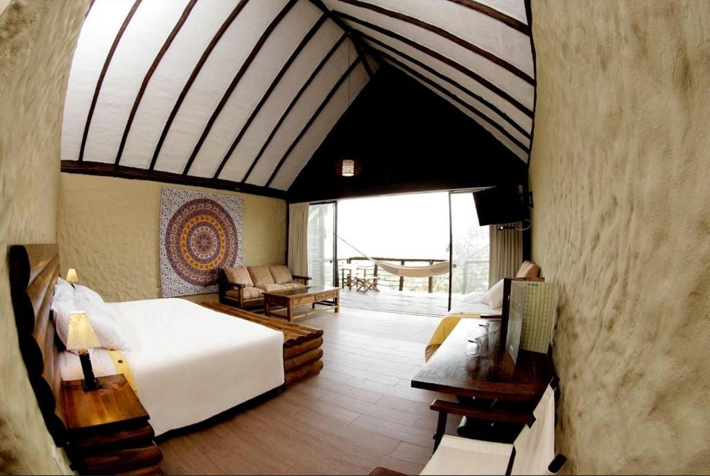 um quarto de hotel com uma cama e uma sala de estar em HOTEL RUSTICA TARAPOTO em Tarapoto