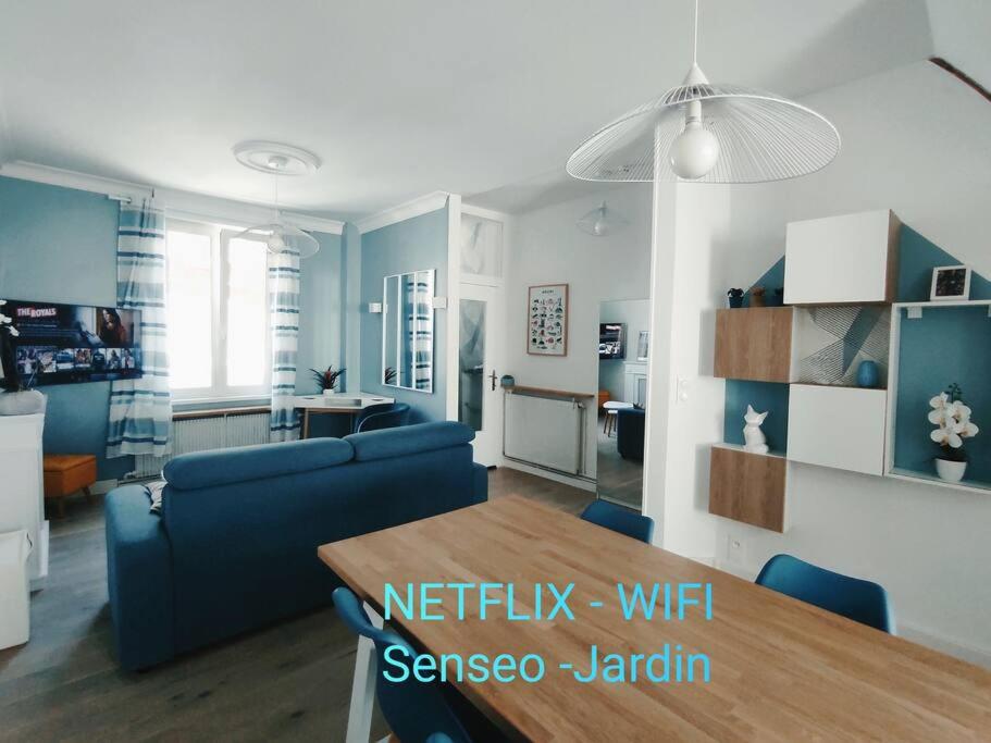 un salon avec un canapé bleu et une table dans l'établissement Maison Amiénoise avec terrasse et jardinet, à Amiens