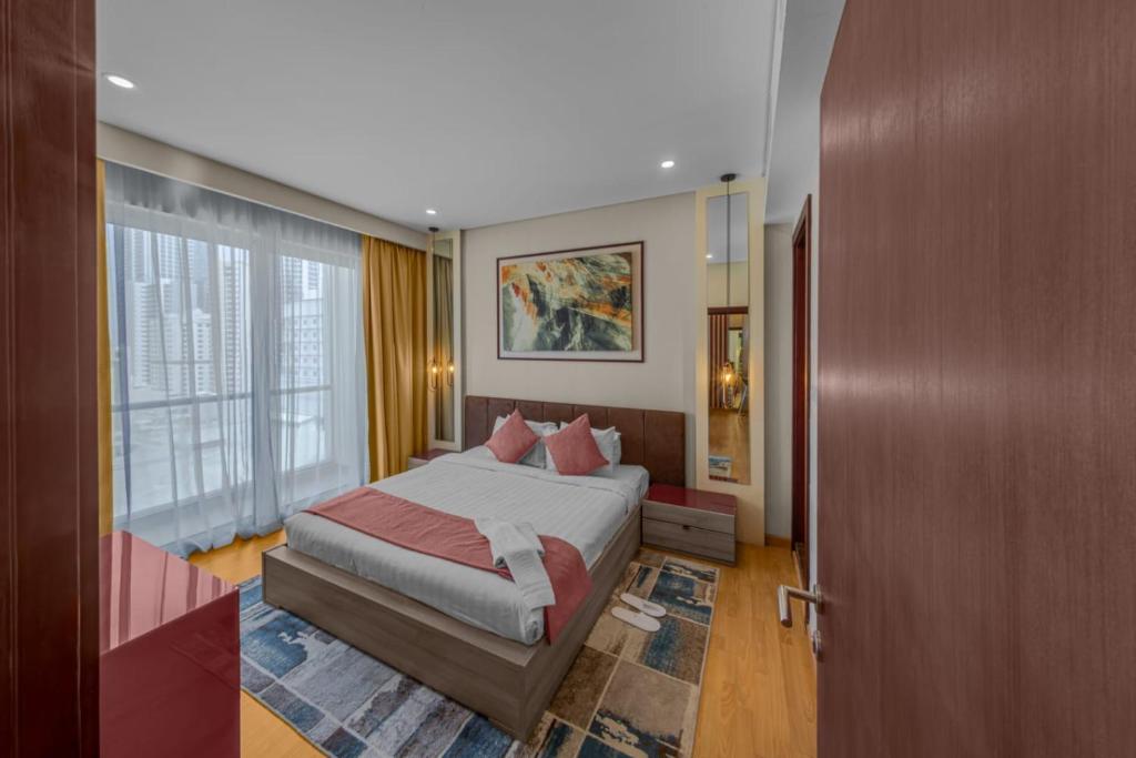 een slaapkamer met een bed en een groot raam bij Afaq Tower in Manamah