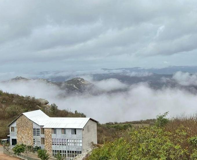 budynek na zboczu wzgórza z chmurami w obiekcie POUSADA MIRANTE DO VALE w mieście Serra de São Bento