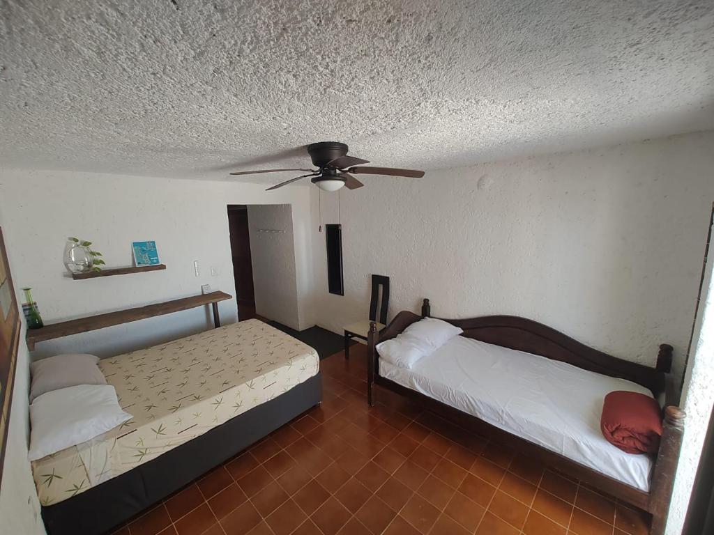 two beds in a room with a ceiling fan at ON THE BEACH SURFERS SUNRISE HAVEN 2 in Cancún