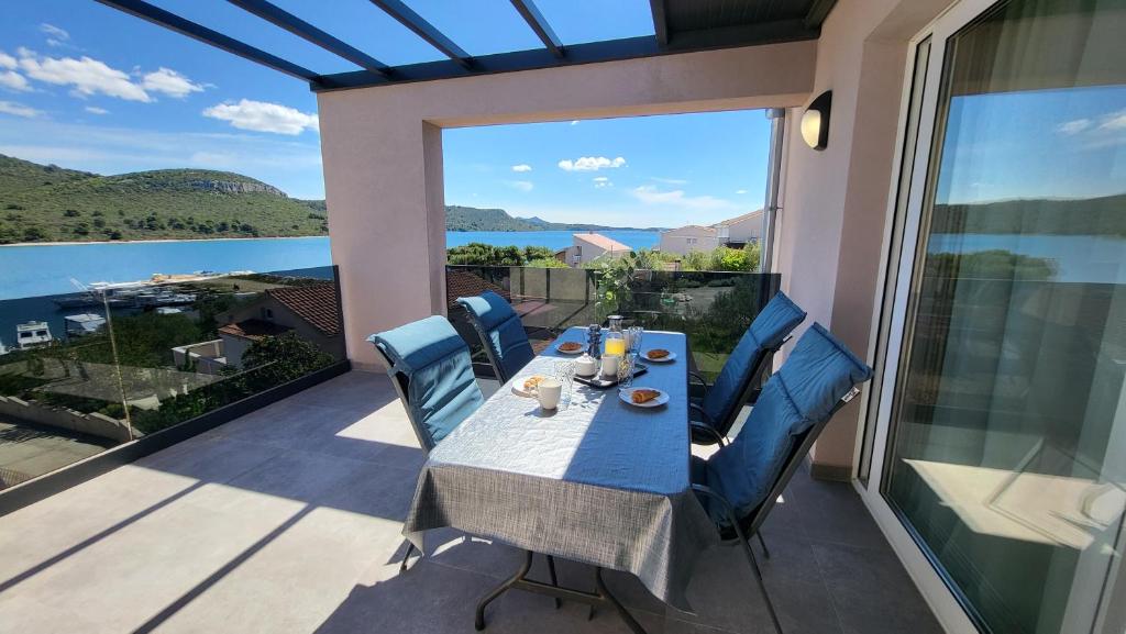 a table and chairs on a balcony with a view of the water at Apartments Amare in Kali
