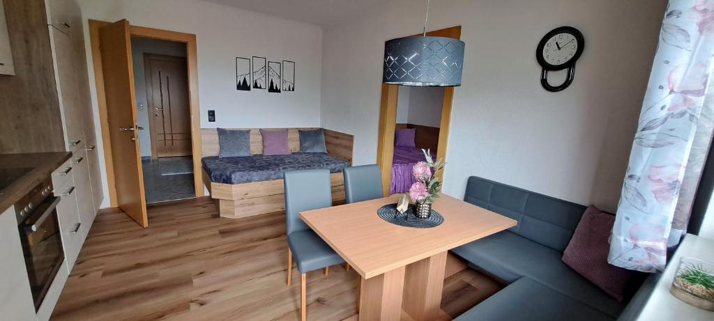 pequeña sala de estar con sofá azul y mesa en Ferienwohnung Steinberger, en Hippach
