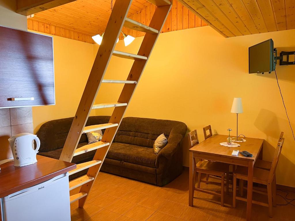 sala de estar con sofá y escalera de madera en AGROTURYSTYKA WIOSNA en Wiosna