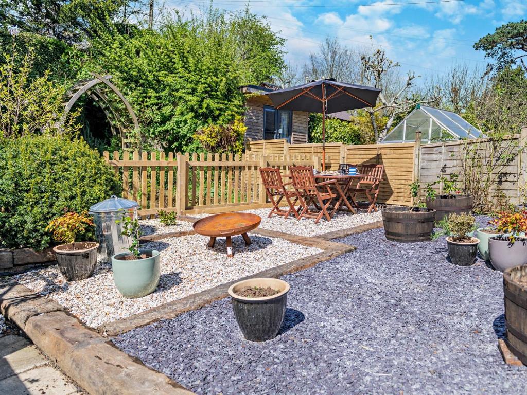 a garden with a table and a bench and an umbrella at 2 Bed in Totnes 94724 in Totnes