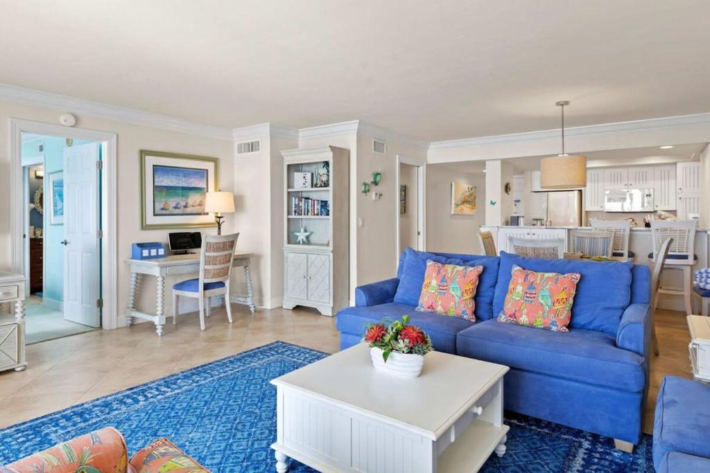 uma sala de estar com um sofá azul e uma mesa em Gorgeous Renovated Residence in Upscale Sanibel Harbour Tower em Fort Myers