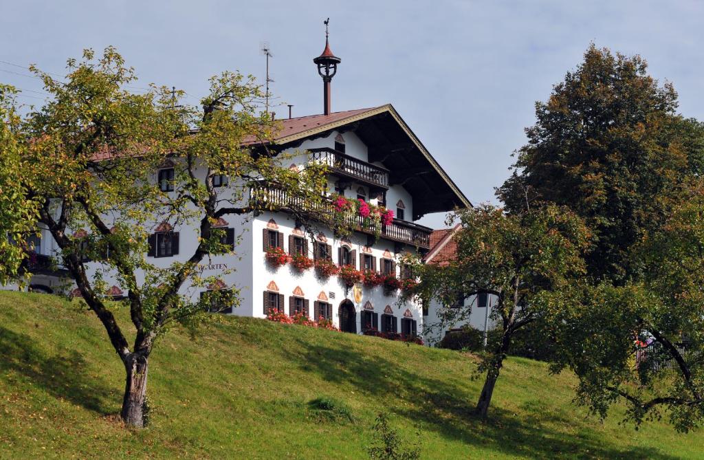 een wit gebouw bovenop een heuvel bij Hotel Baumgarten & Chalet Baumgarten in Angerberg