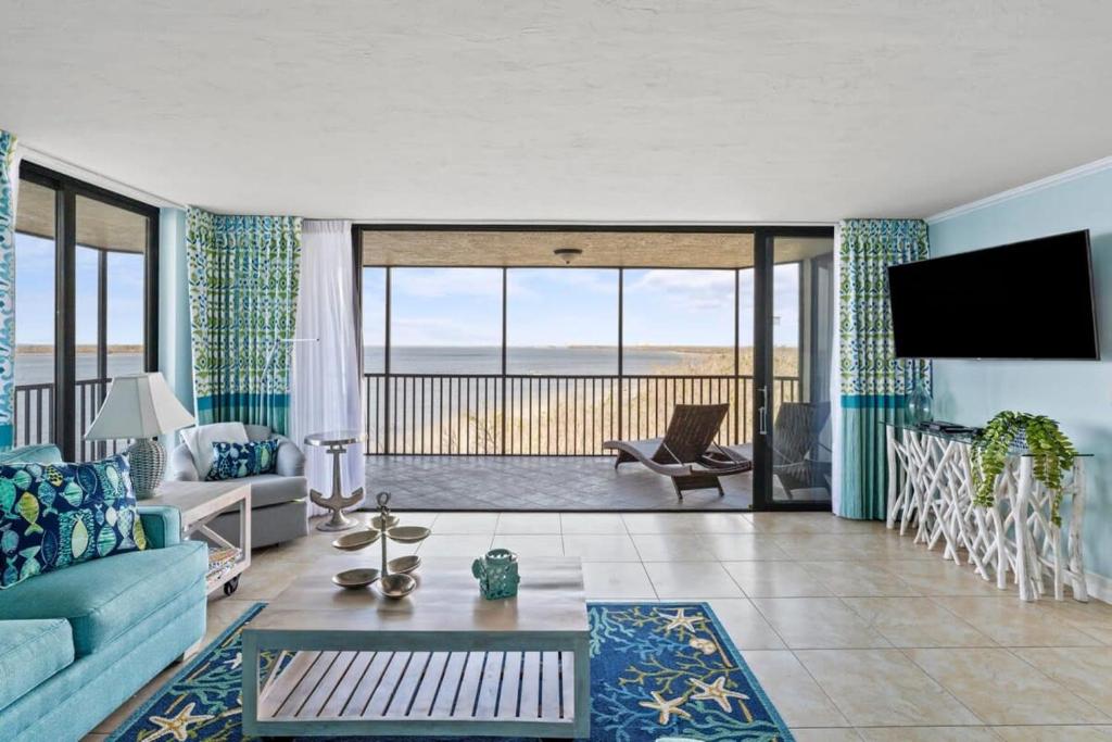 sala de estar con sofá azul y TV en Stunning Waterfront Residence with Panoramic Water Views, en Fort Myers