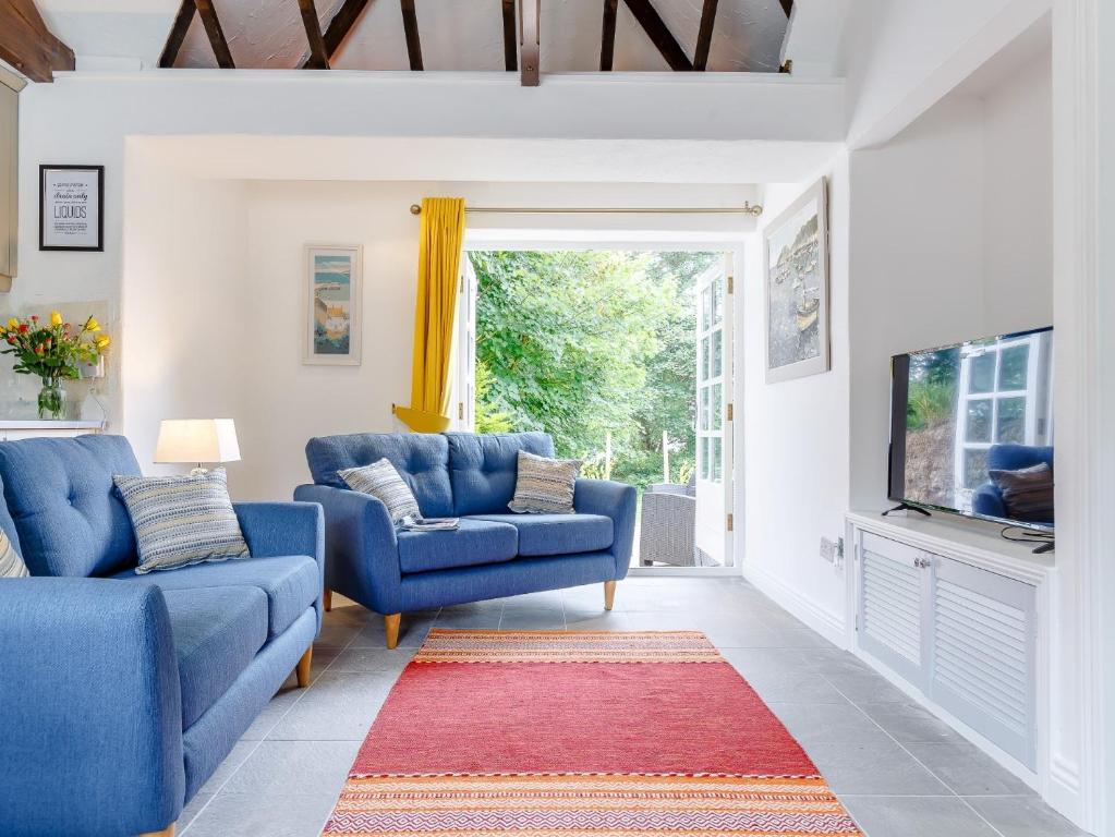 a living room with two blue couches and a tv at 2 Bed in Falmouth 78621 in Penryn