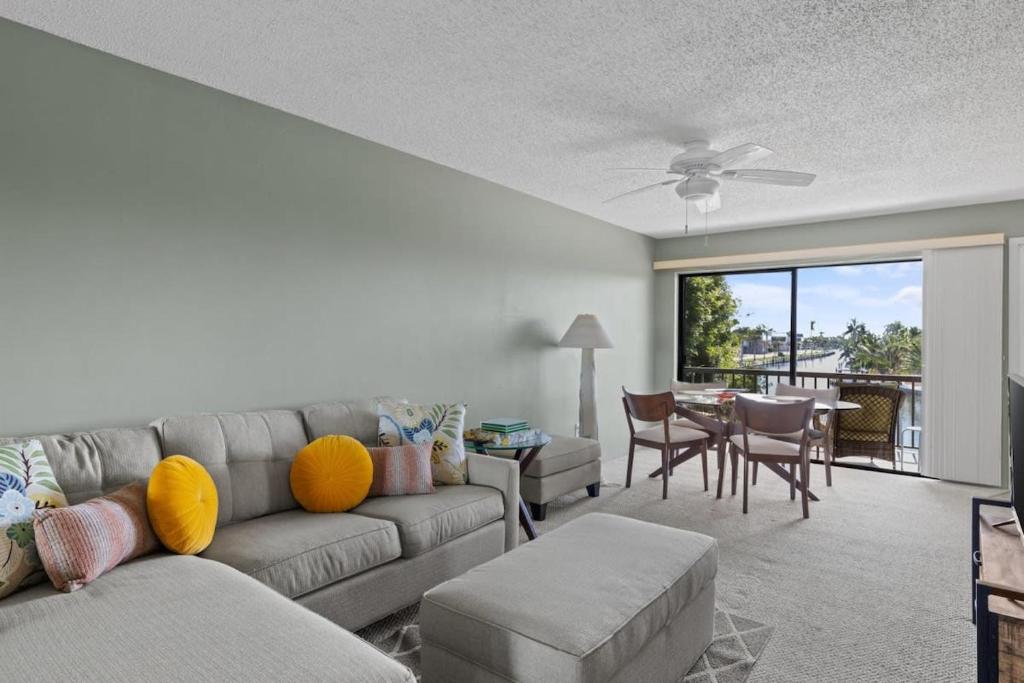 a living room with a couch and a dining room at Comfy Waterfront Condo at Tennisplace Sanibel in Sanibel