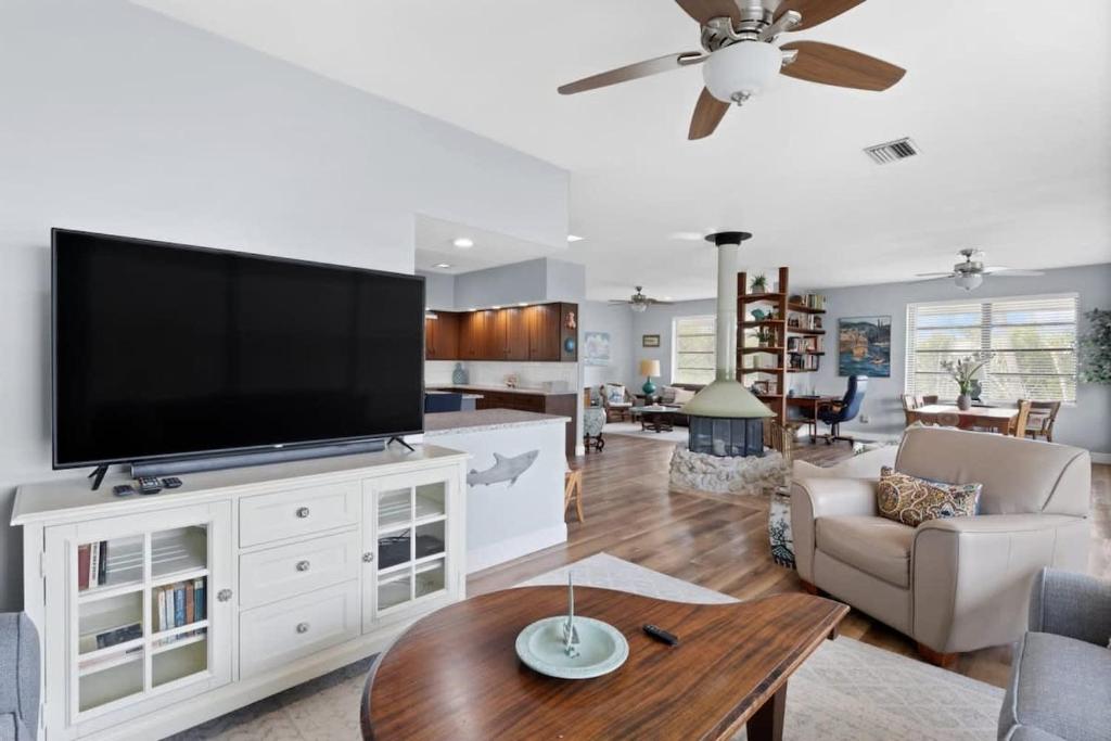 a living room with a flat screen tv on a white entertainment center at Colonel's Cottage- Sanibel Beach Retreat Fantastic Amenities in Sanibel
