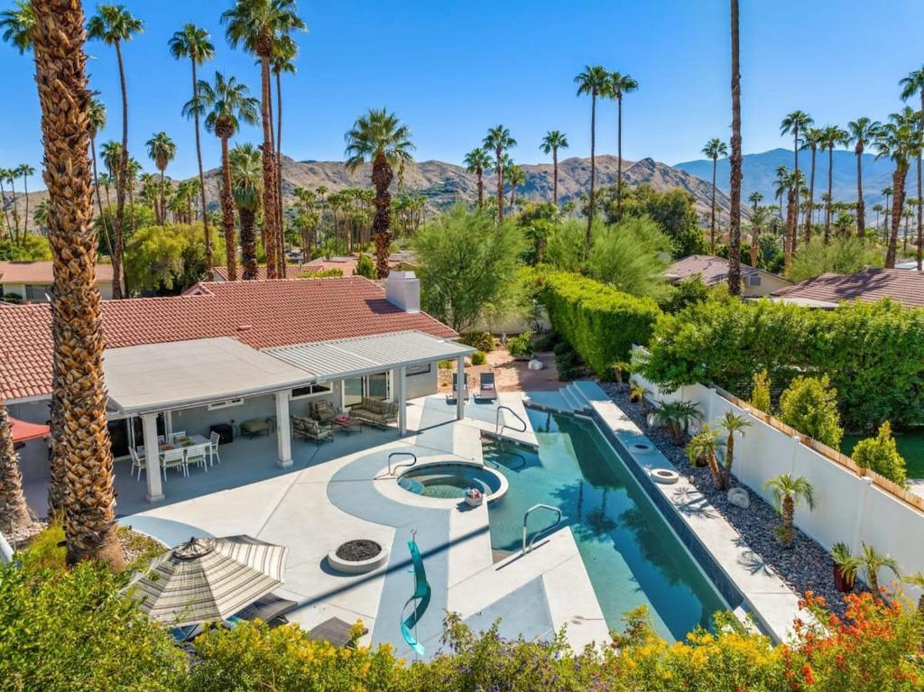 an aerial view of a house with a swimming pool and palm trees at Serenity Palms- Gorgeous Villa in Palm Springs in Palm Springs