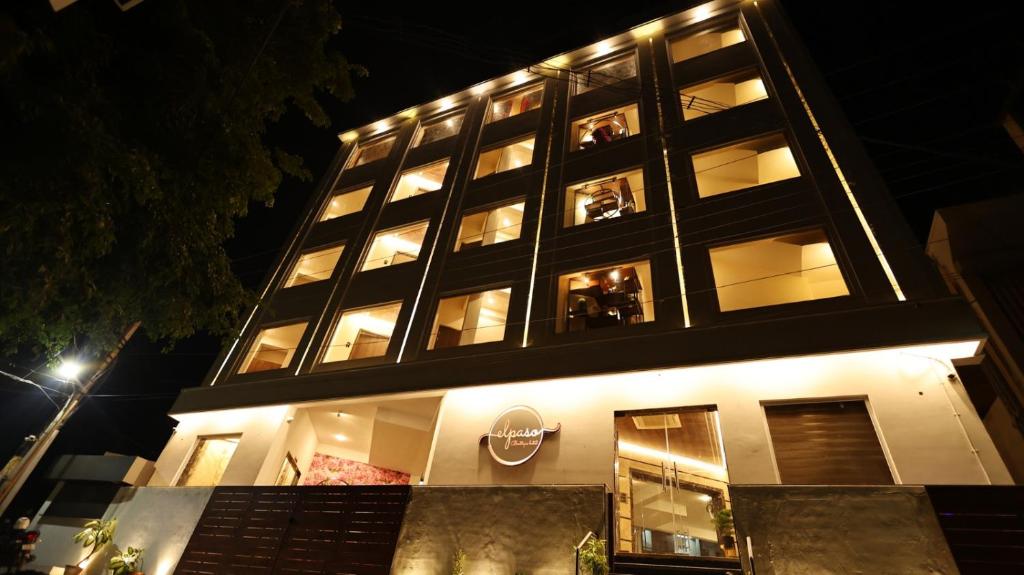 Hotel Elpaso في سالم: مبنى طويل مع الناس في النوافذ في الليل