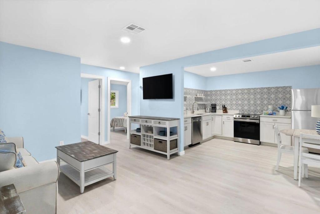 a large kitchen with white cabinets and a living room at Stunning Newly Renovated River District Residence in Fort Myers