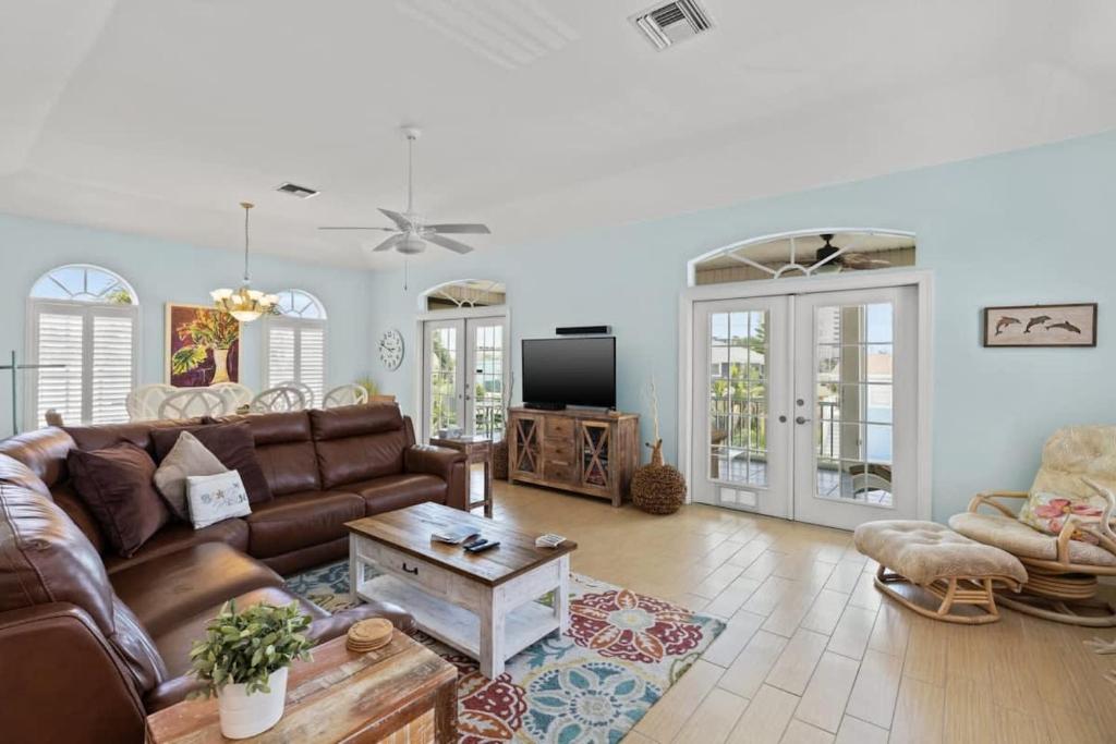 a living room with a couch and a table at Mango Margarita- Beach Home with Pool Sleeps 12 in Fort Myers Beach