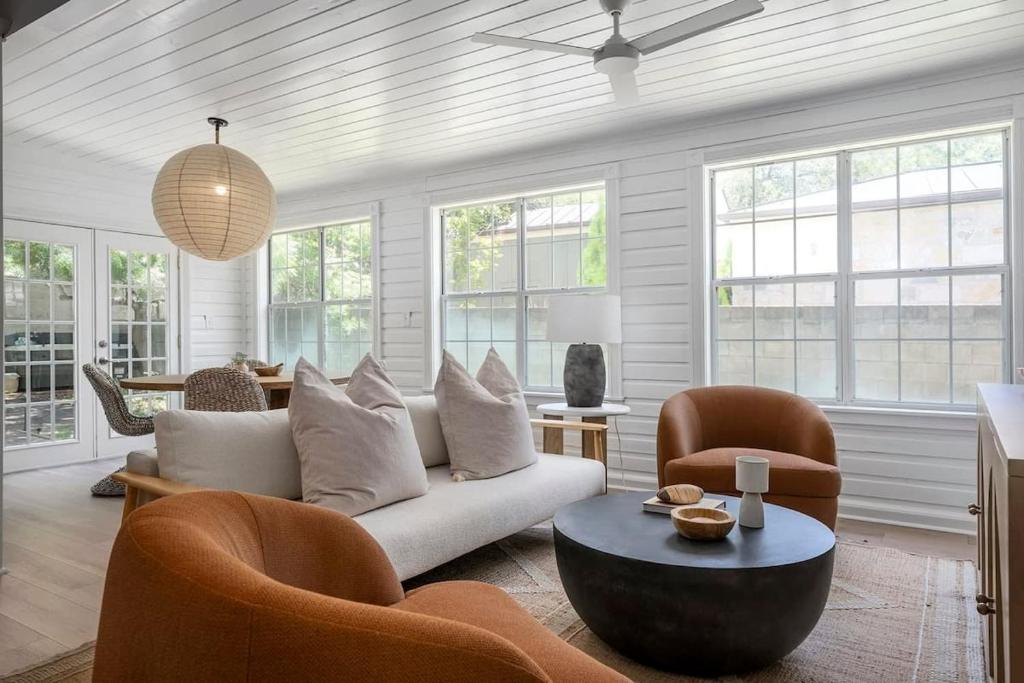 a living room with a white couch and chairs at The Ressman Haus at MarktPlatz with Hot Tub in Fredericksburg