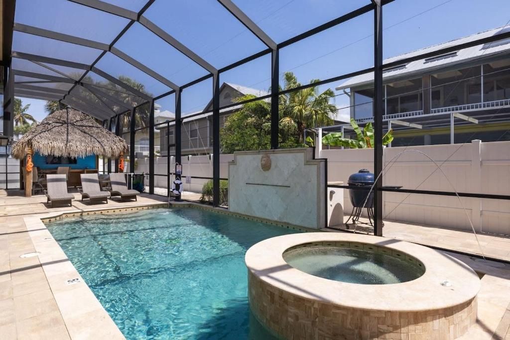 a swimming pool with a building with a roof at Gorgeous Beach Condo with Pool Spa and Bikes in Fort Myers Beach