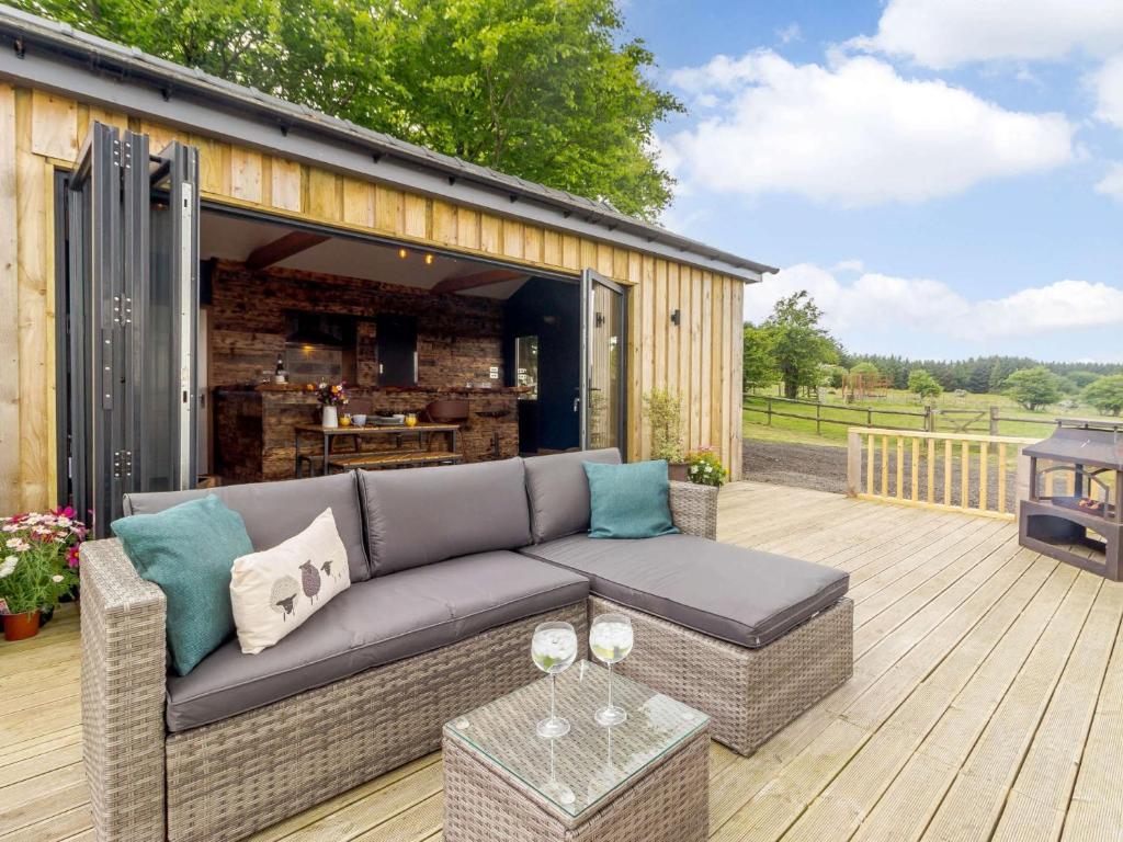 a backyard patio with a couch and a bar at 1 Bed in Abergavenny 88015 in Llanover