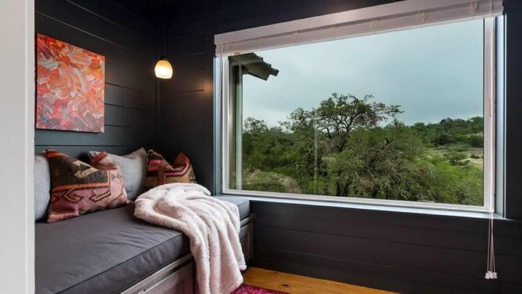 a room with a window and a couch with a blanket at Jumping Goat Ranch-Treehouse Amazing View in Fredericksburg