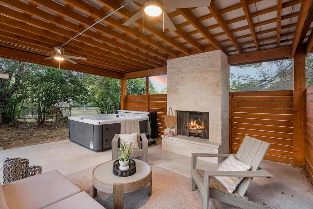 een patio met een open haard en een bank en stoelen bij Riddel Haus Private stylish home plus Hot tub in Fredericksburg