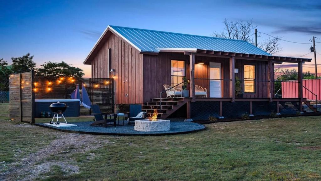 a tiny house with a fire pit in the yard at Sweet Paradise cabin with private hot tub in Fredericksburg
