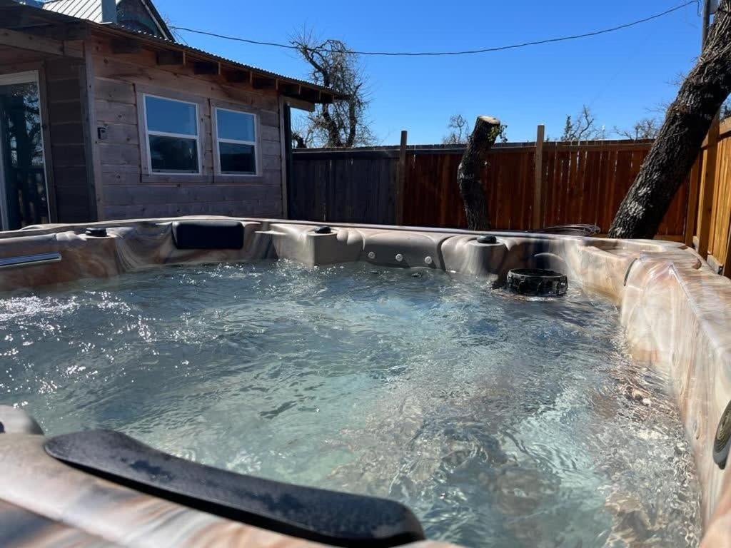 a hot tub in a backyard with a paddle in it at Das Jager Haus Secluded Cabin pet friendly in Fredericksburg