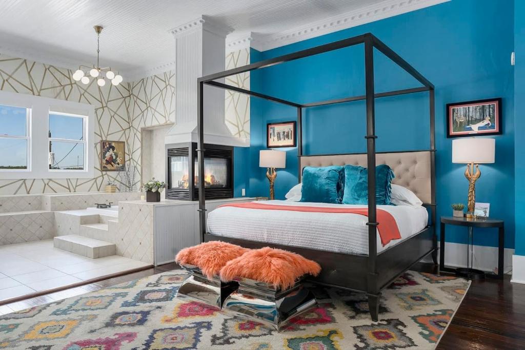 sypialnia z dużym łóżkiem z niebieskimi ścianami w obiekcie The Loft on Main St loft with balcony views w mieście Fredericksburg