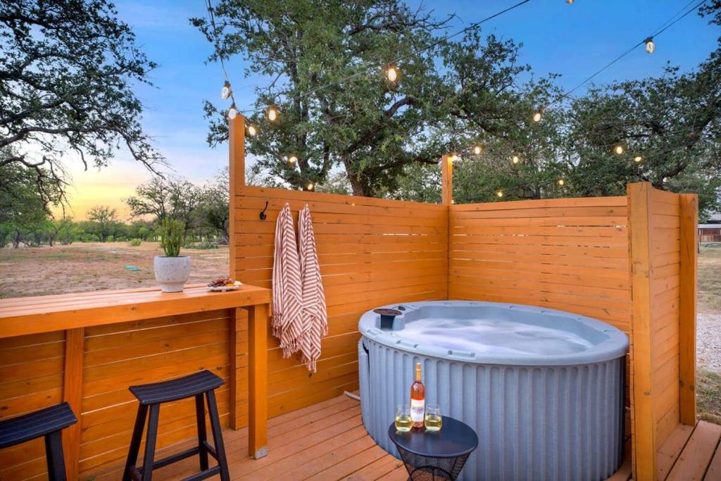 a hot tub on a deck with a wooden fence at Cactus Coterie with Hot tub & pet friendly in Fredericksburg