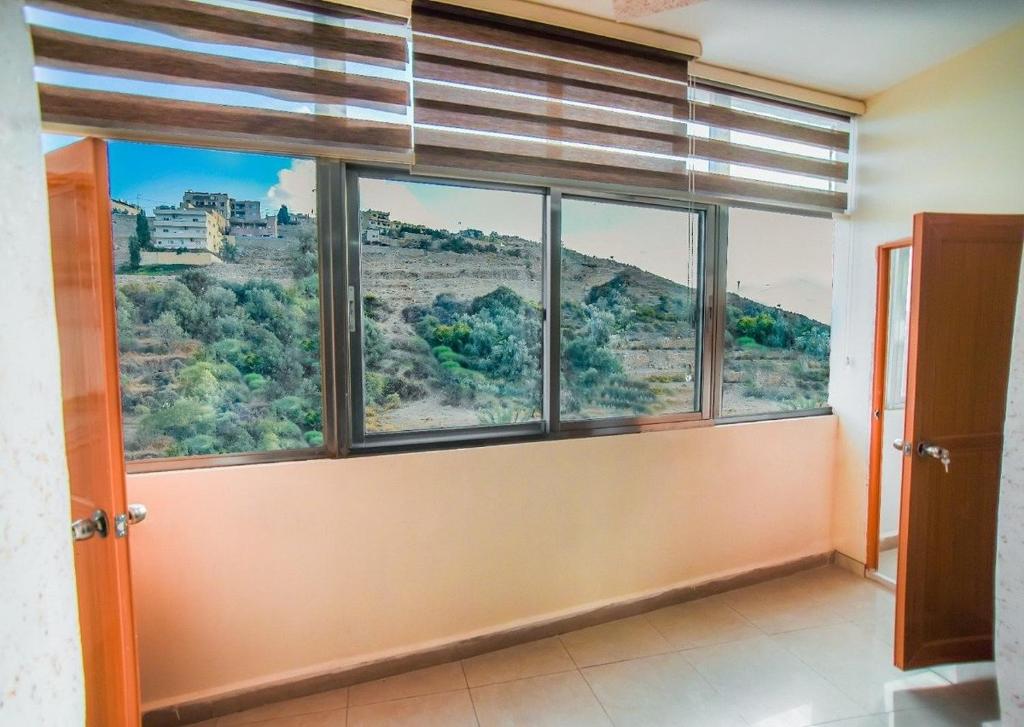 a room with a large window with a view at Petra bods inn in Amman
