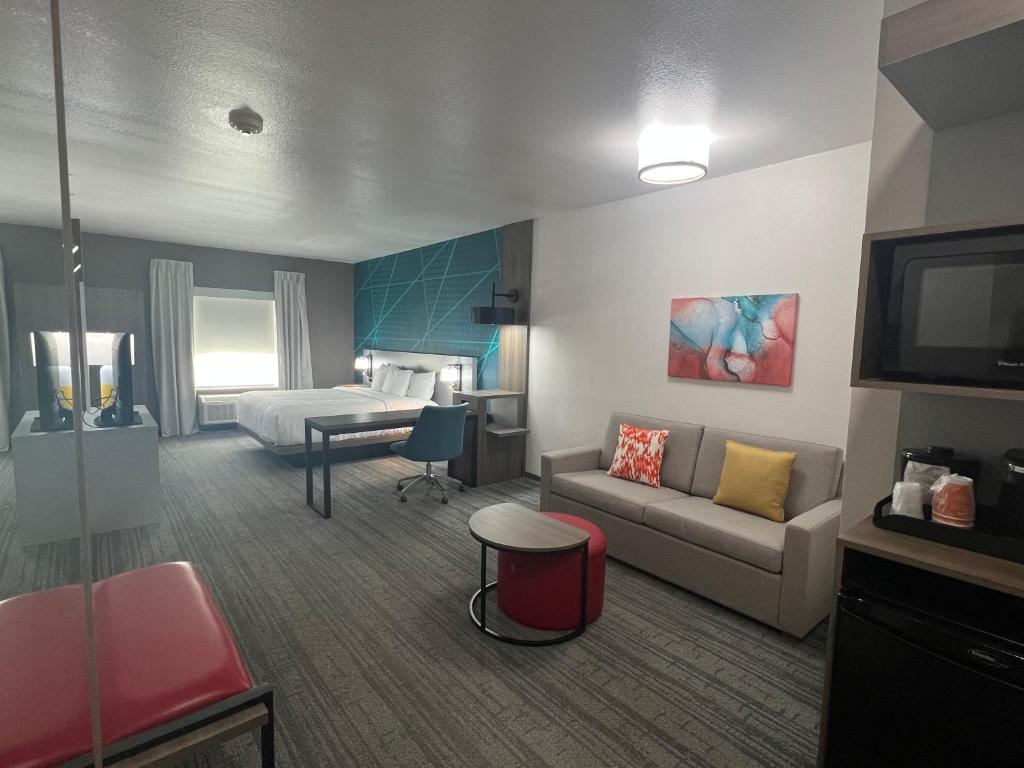 デソトにあるComfort Suites DeSoto Dallas Southのソファとベッド付きのホテルルーム