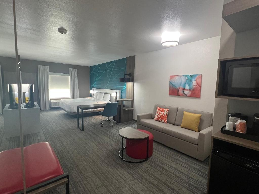 a hotel room with a couch and a bed at Comfort Suites DeSoto Dallas South in DeSoto
