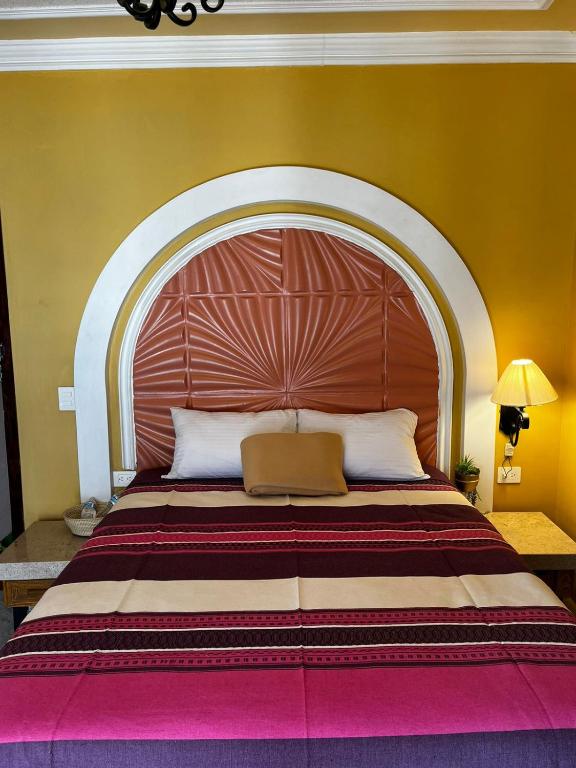 a large bed with a large wooden headboard in a room at Hotel La Casa de María Joyita in Aguascalientes