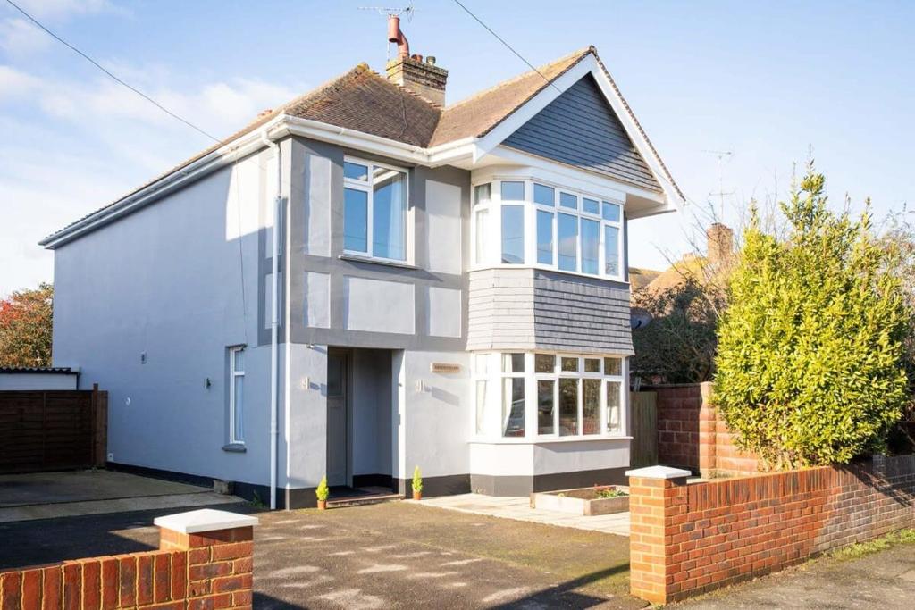 a white house with a red brick fence at Stunning 4br House for 10 Near Beach w Hot Tub in Bognor Regis