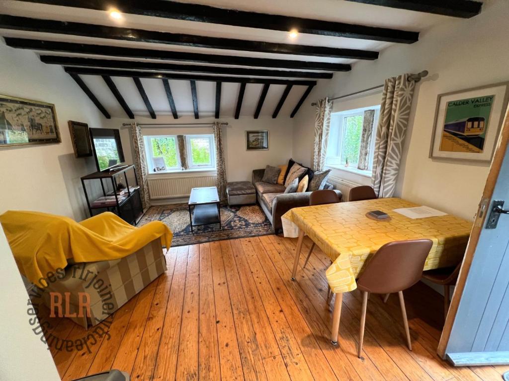 a living room with a table and a couch at Walkers paradise on the Pennine way Charlestown in Halifax