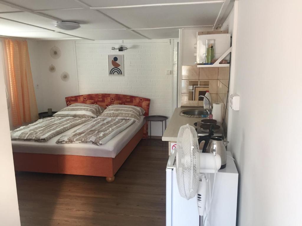 een kleine slaapkamer met een bed en een wastafel bij Bitter súkromné ubytovanie in Štúrovo