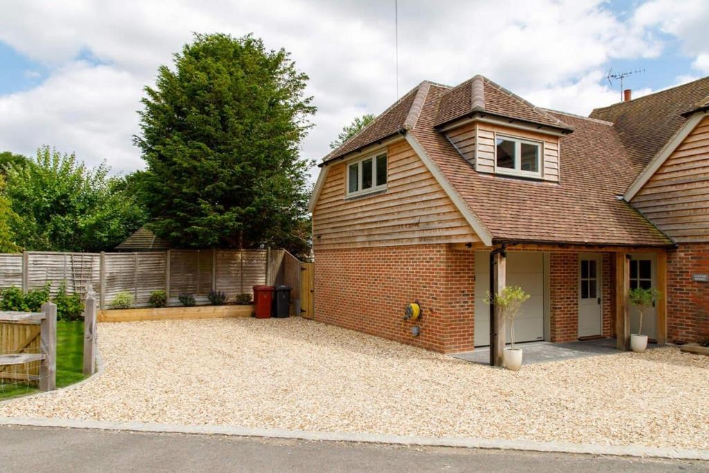 a detached house with a large gravel driveway at Stylish Self-Contained Countryside Accommodation in Chichester