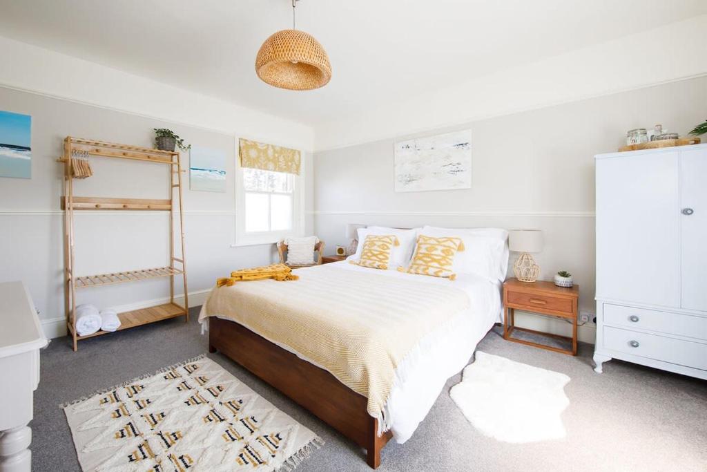 a bedroom with a large bed with yellow pillows at Stocker - King Room in Gastro Pub in West Wittering