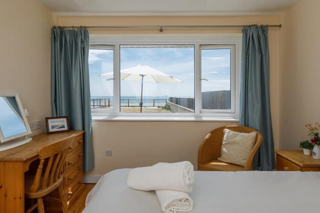 - une chambre avec un lit et une fenêtre donnant sur la plage dans l'établissement Sunny seafront chalet - sleeps 6, à Chichester