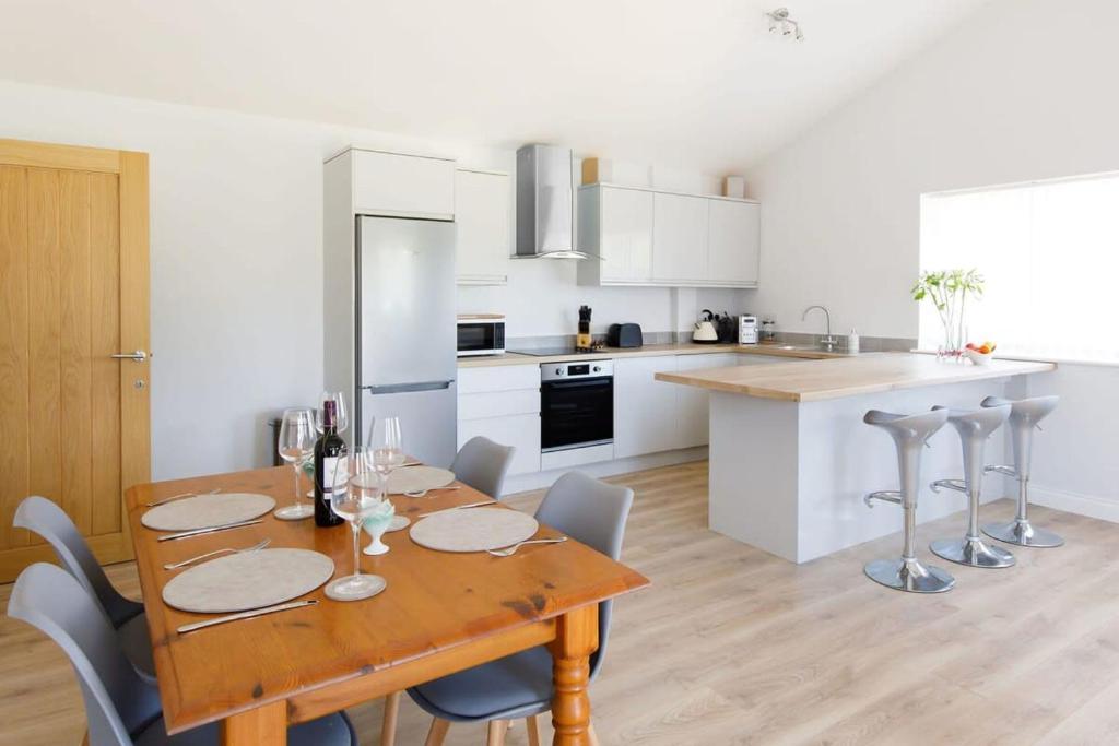 a kitchen and dining room with a wooden table and chairs at Countryside Bungalow for 4 Close to Beaches in Birdham