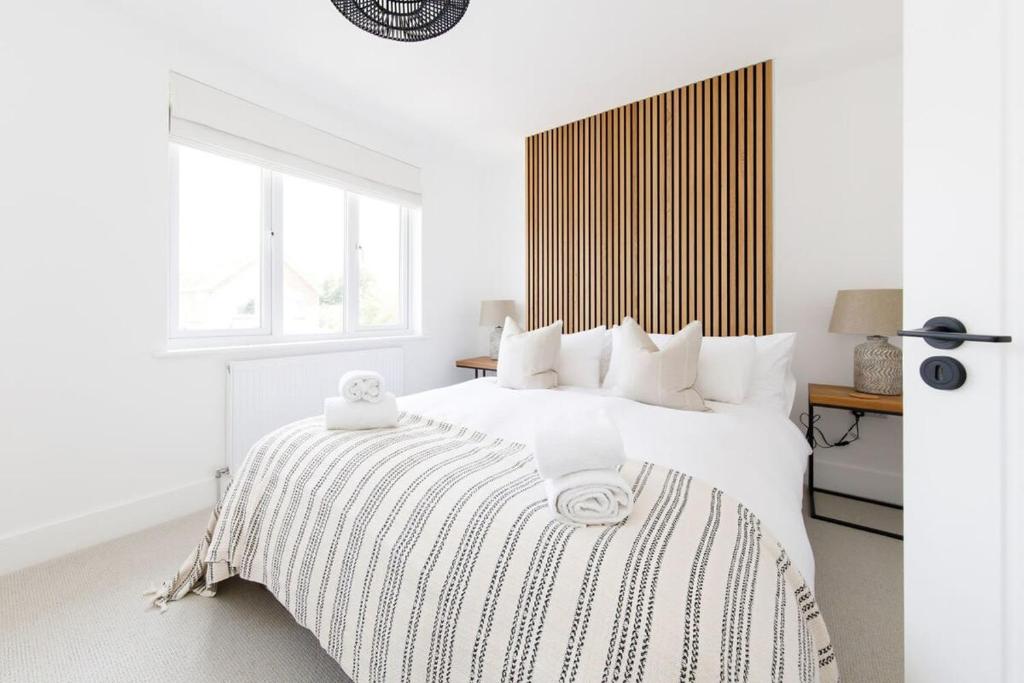 1 dormitorio blanco con 1 cama blanca grande con almohadas blancas en Stylish 2 Bed City Stay, en Chichester