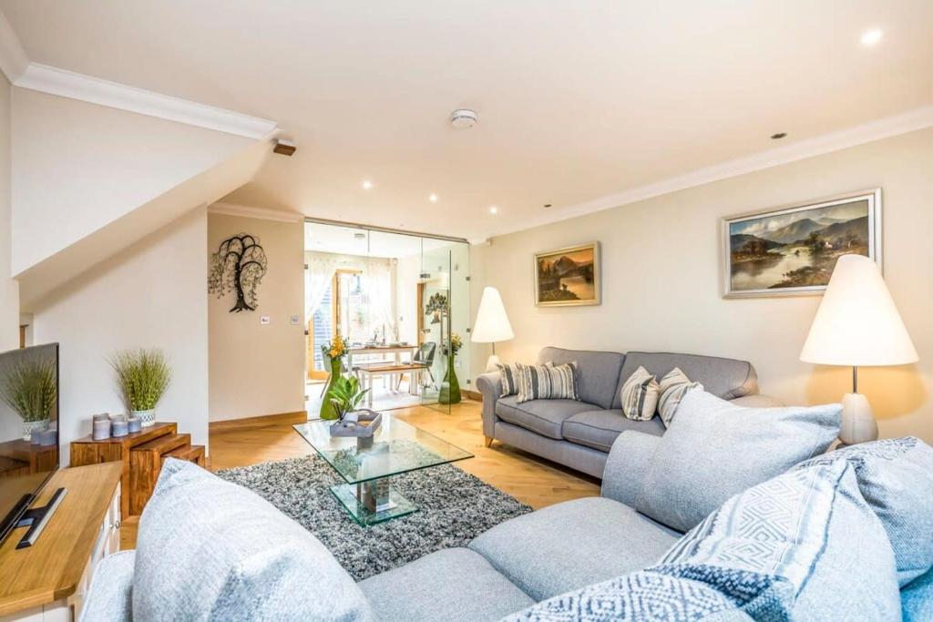 a living room with a couch and a table at Stylish 3 Bed with Double Carport in Fishbourne