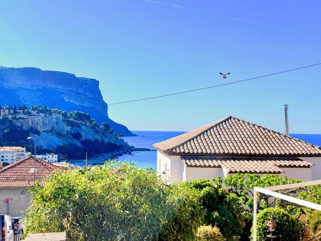 un avion survolant une ville avec une montagne dans l'établissement Lou Castèu, à Cassis