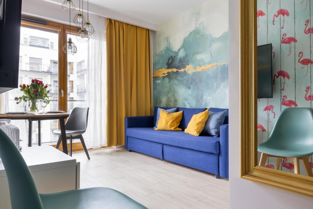 a living room with a blue couch and a table at Flamenco Apartament Gdańsk in Gdańsk