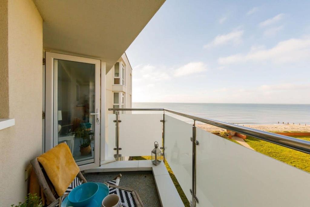 a balcony with a view of the beach at Two Bed Seafront Escape in East Wittering in East Wittering