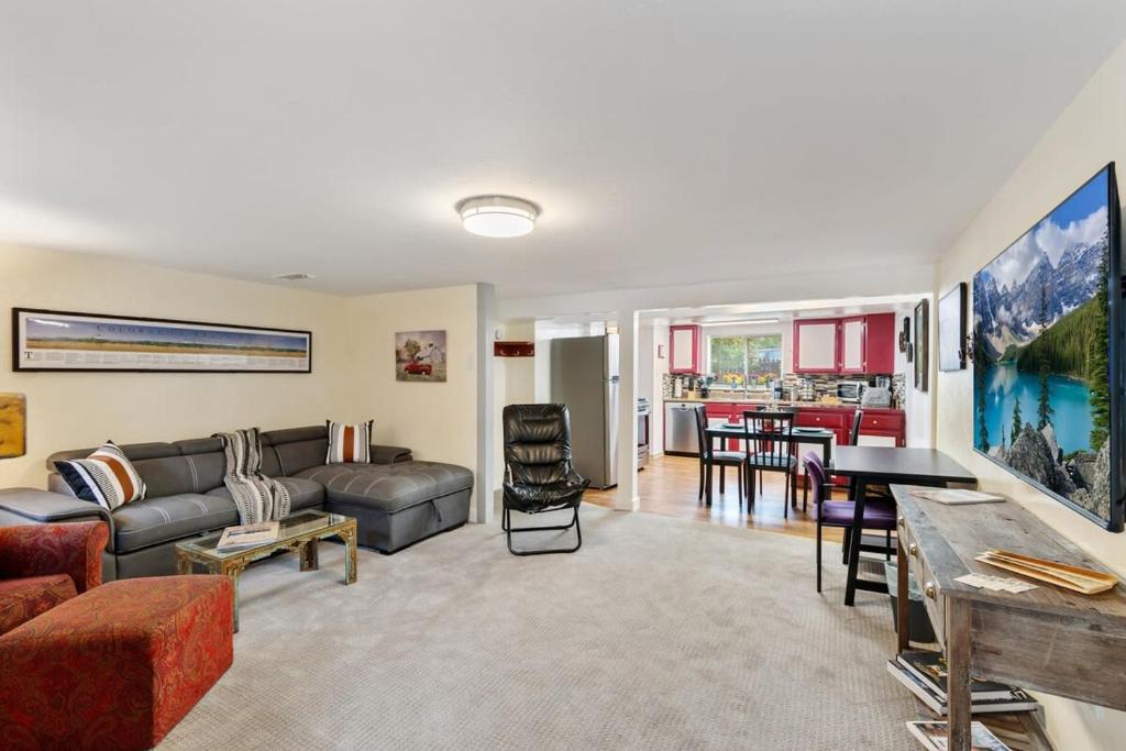 uma sala de estar com um sofá e uma mesa em Cozy & Spacious Apartment Steps From Regis em Denver