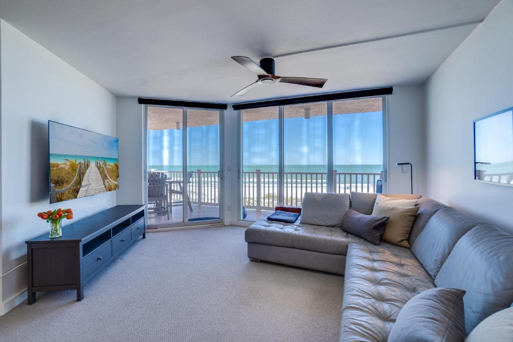 a living room with a couch and a television at Bella Luna, 2 bed and 2 bath beachfront condo in Bradenton Beach