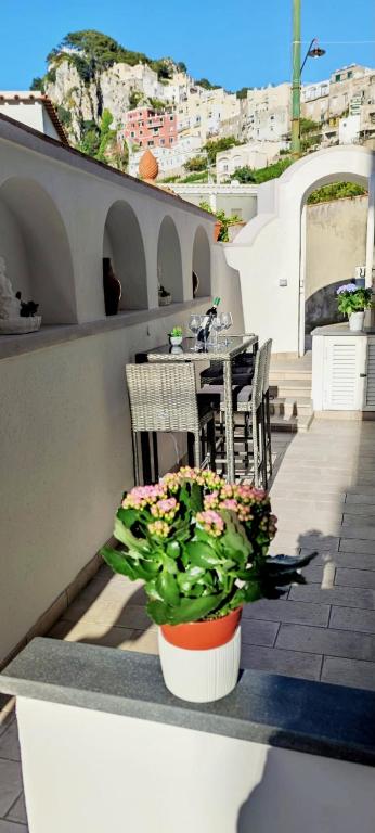 a patio with a table and chairs and flowers at LuSi Capri House in Capri